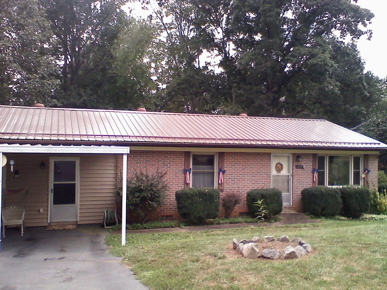 Bronze metal roof and carport on a brick ranch home — Roof Repair work by our crew in Polk